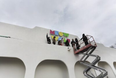 Installing-the-Meow-Wolf-sign_Photo-by-Lindsey-Kennedy_House of Eternal Return: The Original Meow Wolf by Jordan Rumsey